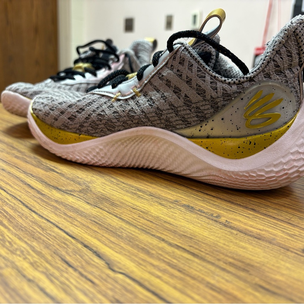 Under Armour Corry Young Wolf 
Gray and Gold Athletic Shoes